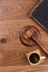 Topview wooden hammer with cup of coffee. Brown wooden table surface.