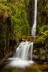 Fototapeta na wymiar Scale Force waterfall in the English Lake District covered in green moss.