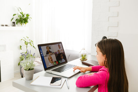 Pretty stylish schoolgirl studying homework math during her online lesson at home, social distance during quarantine, self-isolation, online education concept, home schooler