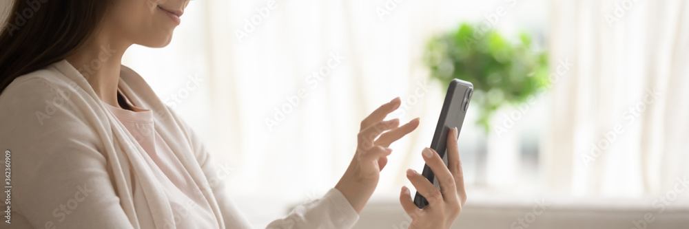 Wall mural satisfied young woman holding smartphone, browsing mobile device app close up cropped wide image, be