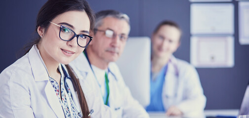 Serious medical team using a laptop in a bright office