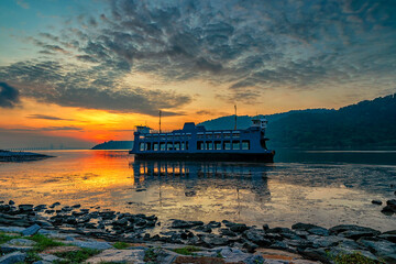 Magnificent view of the sunrise view with an unused ferry floating on the low tide water.