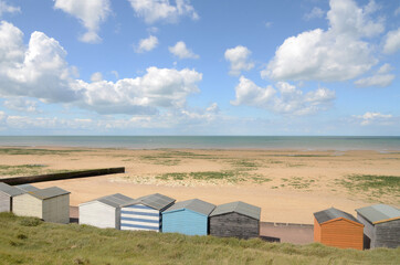 Fototapeta na wymiar Beach and beach huts at Minnis Bay, Kent, UK in the Summer