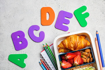 Back to school concept. Lunch box with sandwich, croissants and snacks for school. School...
