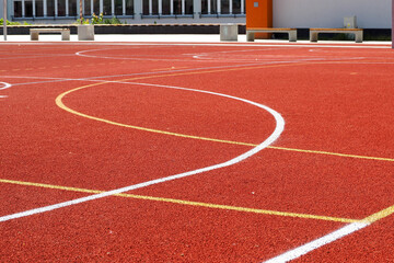 Red soccer field with white and orange stripes . stadium