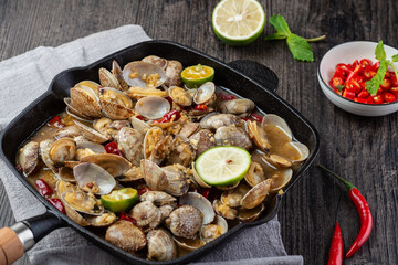 Fototapeta na wymiar Boiled clams with chili in an iron pot