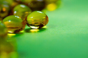 vitamins in capsules are yellow on a green background.close up.the concept of vitamin and mineral deficiency for the health of the body.space for text.