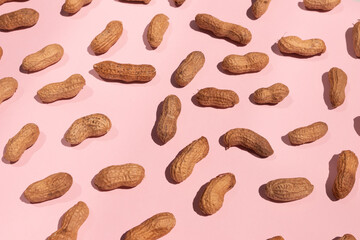 whole peanuts isolated on pink background