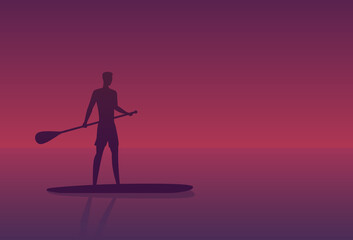Man on a sup board at sunset