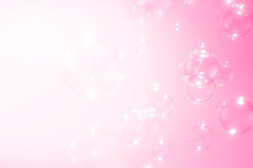 Soap bubbles float on pink background.