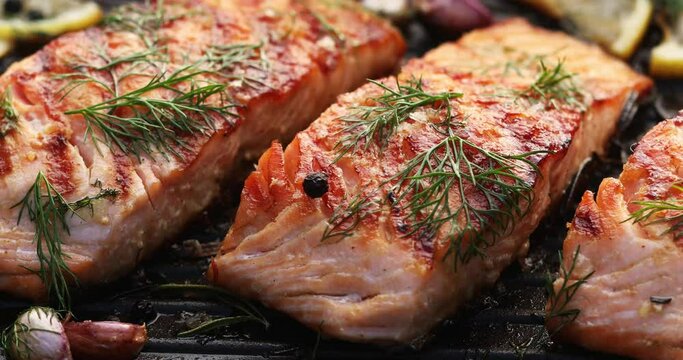 Grilled salmon fillets on a grill plate drizzled with lemon juice
