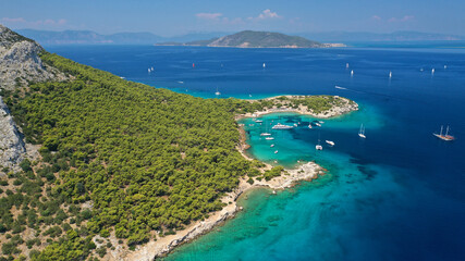 Fototapeta na wymiar Aerial drone photo of beautiful exotic turquoise sea rocky Mediterranean island forming a blue lagoon visited by sail boats and yachts
