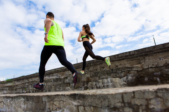 Sporty young couple in stylish sportswear running on stairs, photography for blog or ad of sport and healthy lifestyle