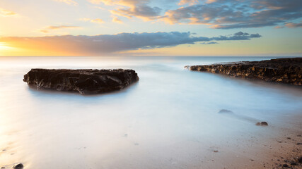 coucher de soleil sur la plage, rocher, vague et sable