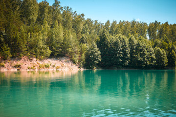 Forest lake with an emerald color of water.
