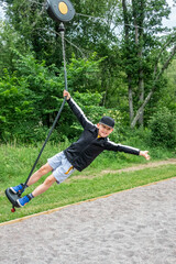 Sporty child smiling riding a zip-line at an playground in a public park.