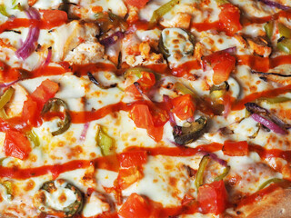 Delicious classic Mexican pizza with meat, peppers, onions, tomatoes, jalapeno and cheese close-up on top