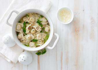 Boiled Italian ravioli stuffed with chicken ground in white cooking pot