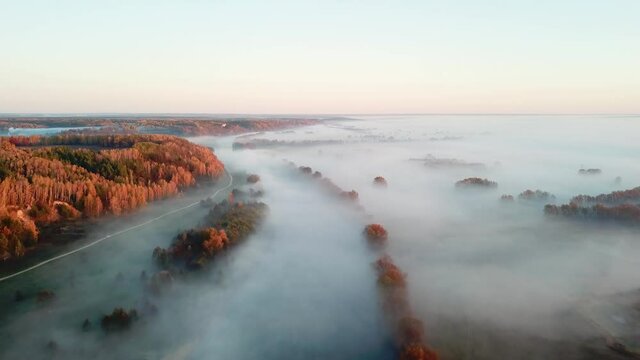 Aerial view of morning fog over autumn river, flight over river at sunrise, dawn over the river in the morning mist, river in the morning mist, Sunny and foggy morning over the river