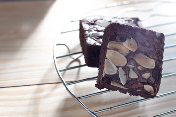 Two almonds brownies on a natural wood background
