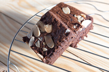 Two almonds brownies on a natural wood background