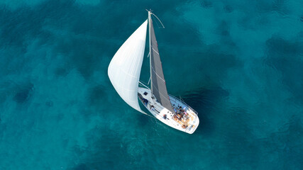 Aerial drone photo of beautiful sail boat cruising in low speed the Ionian turquoise calm sea