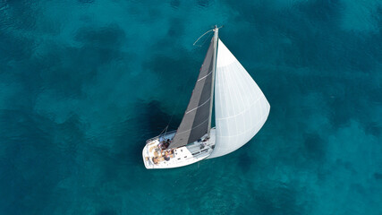 Aerial drone photo of beautiful sail boat cruising in low speed the Ionian turquoise calm sea