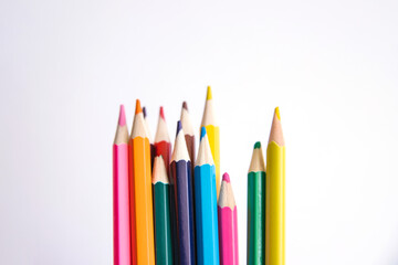 Colored pencils on a white background. Variety of colors. School supplies.