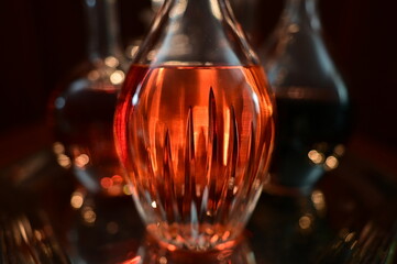 Closeup of decanters on silver tray containing variety of liquors with very limited depth of field.
