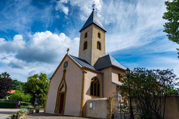 Fototapeta na wymiar Belle petite église Saint-Rémy de Scy à Scy-Chazelles sur un ciel bleu du 11ème siècle