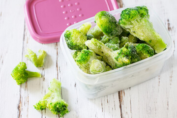 Healthy food is frozen. Containers with frozen broccoli.