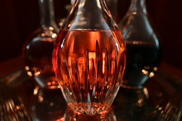 Closeup of decanters on silver tray containing variety of liquors with limited depth of field.