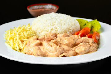 beef stroganoff served with white rice, potato straw and cooked vegetables