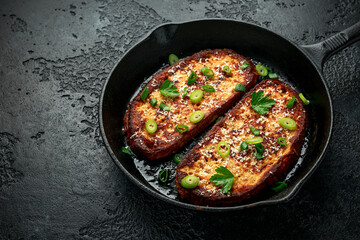 Obraz na płótnie Canvas Parmesan cheese French Toast with spring onion on cast iron pan