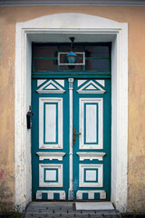 Green entrance door with white elements