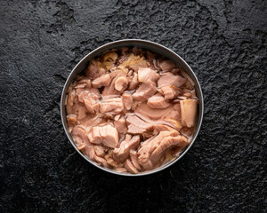 Canned tuna fish with olive oil on rustic stone background