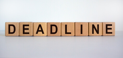 Concept word 'deadline' on wooden cubes on a beautiful wooden table. White background. Business concept.
