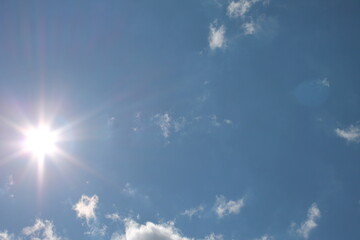 Naklejka na ściany i meble Sunny background, blue sky with white clouds and sun