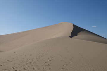 Fototapeta na wymiar sand dunes under sunny blue sky. simplicity. At Dunhuang, Gansu province, China