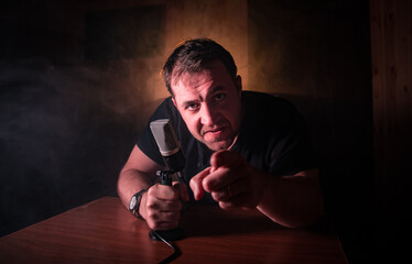 Serious reporter in television studio looking at the camera