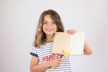 Fototapeta na wymiar Beautiful little girl smiling with a notebook