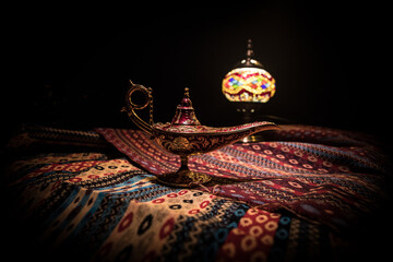 Lamp of wishes concept. Antique Aladdin arabian nights genie style oil lamp with soft light white...