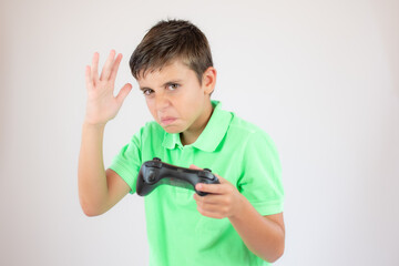 Little boy with green polo shirt concentrated with the game controller