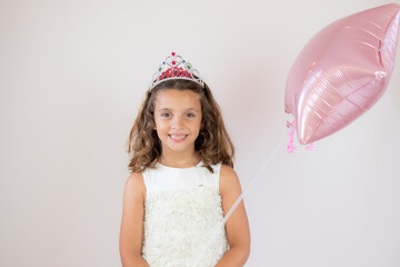 Beautiful girl smiling holding a pink balloon with her hand