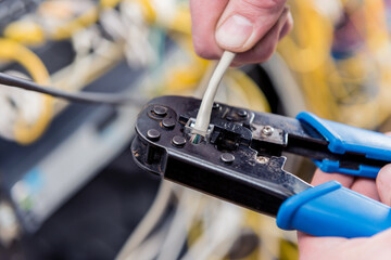 Naklejka premium Network engineer working in server room. Connecting network cables to switches