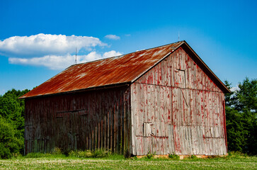 Obraz premium Old faded wooden red barn in the Midwest