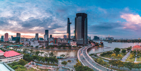 Fototapeta na wymiar Ho Chi Minh city at sunset, Khanh Hoi bridge, yellow trail on street, the building in picture is bitexco tower, Far away is landmark 81 skyscraper