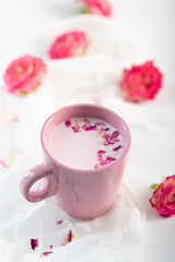 Obraz na płótnie Canvas Moon milk prepares with pink rose flower. Trendy relaxing bedtime drink form Ayurvedic traditions
