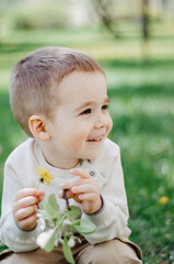 Cute child with wildflowers in sun back light