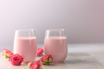 Moon milk prepares with pink rose flower. Trendy relaxing bedtime drink form Ayurvedic traditions with copy space
